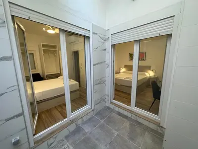 a room with two windows and a bedroom with a bed at Valdeolivas Suites in Valencia