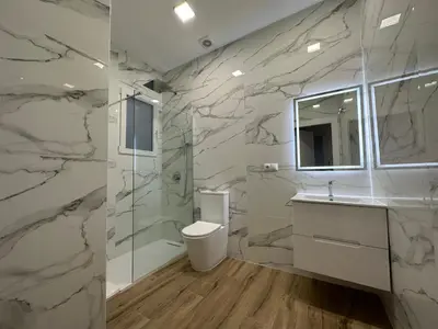 a marble bathroom with a toilet and a sink at Valdeolivas Suites in Valencia