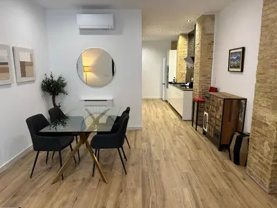 a dining room with a glass table and chairs at Valdeolivas Suites in Valencia