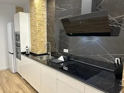 a kitchen with a sink and a black counter top at Valdeolivas Suites in Valencia