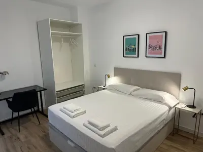 a bedroom with a bed with a desk and a chair at Valdeolivas Suites in Valencia