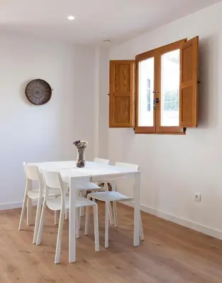 a white dining room with a white table and chairs at Mar de fonts ain in Ahín