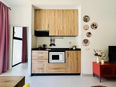 a kitchen with wooden cabinets and a microwave at Sweet Aparment in Russafa (Soho) in Valencia