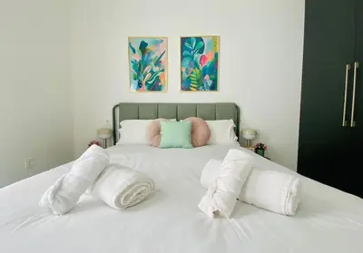 a white bed with three pillows on it at Sweet Aparment in Russafa (Soho) in Valencia