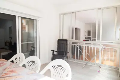 a room with a balcony with a table and chairs at El hogar del mar. in Sueca