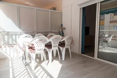 a dining room with a table and chairs on a balcony at El hogar del mar. in Sueca