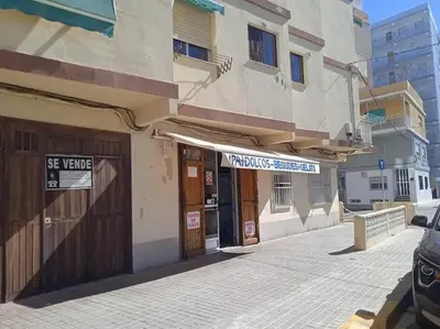 a building on a street with a sign on it at El hogar del mar. in Sueca