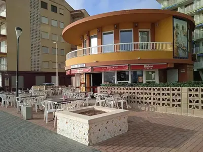 a restaurant with tables and chairs in front of a building at El hogar del mar. in Sueca