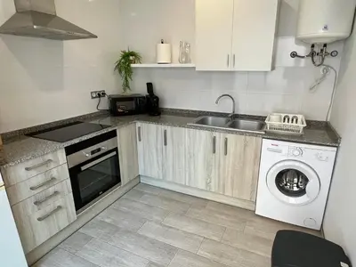 a kitchen with a sink and a washing machine at Bonita Planta baja con patio en 1ª línea de playa in Puerto de Sagunto