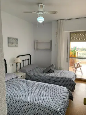 two beds sitting in a bedroom with a window at Big Gran Khan Apartment Canet den Berenguer con Piscina in Canet de Berenguer