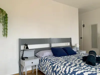 a bedroom with a bed with blue pillows at Big Gran Khan Apartment Canet den Berenguer con Piscina in Canet de Berenguer