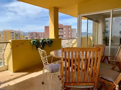 a patio with a table and chairs on a balcony at Big Gran Khan Apartment Canet den Berenguer con Piscina in Canet de Berenguer