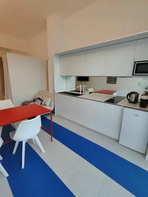 a kitchen with a red table and white cabinets at CariSan2 - fully equipped, 6 min to beach in Valencia