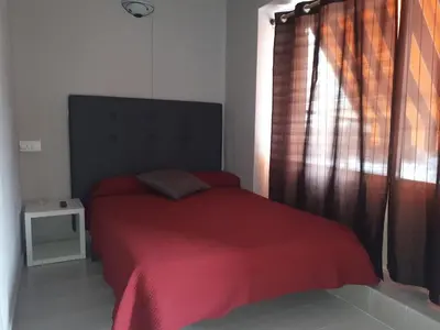 a bedroom with a red bed with a red blanket at Pensión Jamaica in Valencia