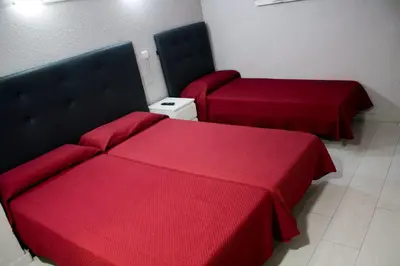 a room with a bed with a red blanket at Pensión Jamaica in Valencia