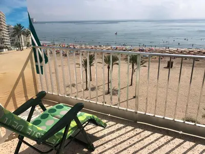 a balcony with a chair and a view of the beach at Vistas espectaculares 