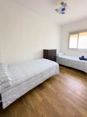 a bedroom with two beds and a wooden floor at Apartamento Los Narcisos 2 in Chulilla