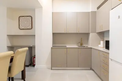 a kitchen with white cabinets and a table at Luxury Apartment City Center in Valencia