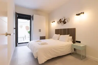a bedroom with a large white bed and a window at Luxury Apartment City Center in Valencia