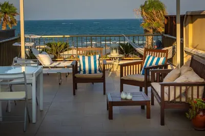 a balcony with chairs and tables and the ocean at Patacona Sunrises Premium in Valencia