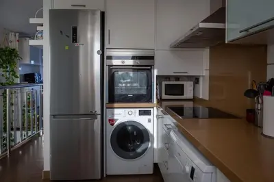 a kitchen with a washing machine and a refrigerator at Patacona Sunrises Premium in Valencia