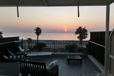 a balcony with a view of the ocean at sunset at Patacona Sunrises Premium in Valencia