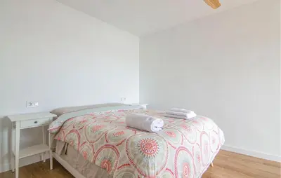 a bedroom with a bed and a table with towels on it at Beautiful Apartment In Cullera in Cullera