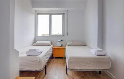 two twin beds in a room with a window at Beautiful Apartment In Cullera in Cullera