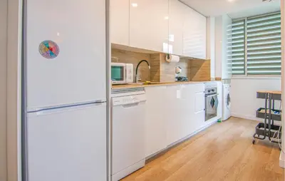 a kitchen with white cabinets and a refrigerator at Beautiful Apartment In Cullera in Cullera