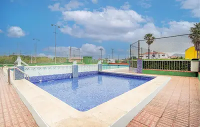 a swimming pool on a brick patio with a fence at Beautiful Apartment In Cullera in Cullera