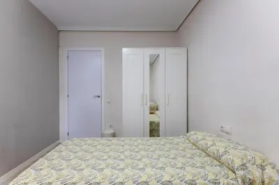a bedroom with a bed and a white wall at Acogedor apartamento en Valencia cerca de la playa in Valencia