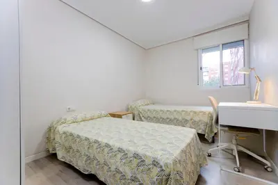 a bedroom with two beds and a desk and a sink at Acogedor apartamento en Valencia cerca de la playa in Valencia