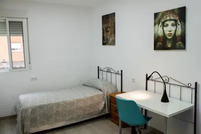 a bedroom with a bed and a desk and a bed and a table at Precioso apartamento en Malvarrosa Playa Valencia in Valencia