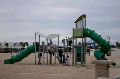 a playground with a green slide on the beach at Precioso apartamento en Malvarrosa Playa Valencia in Valencia