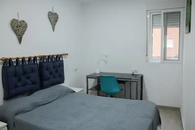 a bedroom with a bed and a desk and a chair at Precioso apartamento en Malvarrosa Playa Valencia in Valencia