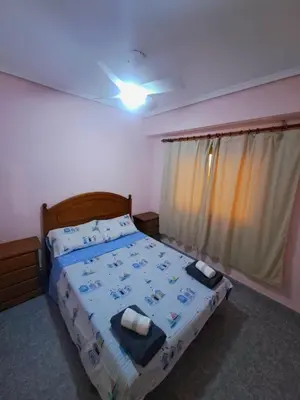 a bedroom with a bed with a blue comforter at Gabriella Apartment Near the beach in Puerto de Sagunto