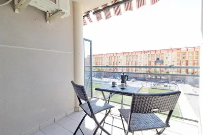 a balcony with a table and two chairs and a window at Global Vacacional, Bonito apartamento en Puerto Sagunto para parejas in Puerto de Sagunto