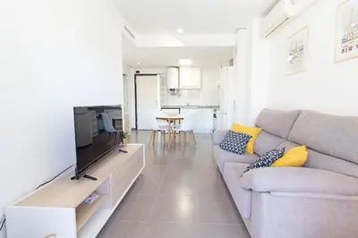 a living room with a couch and a tv at Global Vacacional, Bonito apartamento en Puerto Sagunto para parejas in Puerto de Sagunto