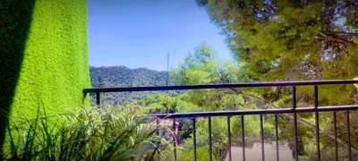 a balcony with a green wall and trees at Apartamento en la montaña, Serra in Serra