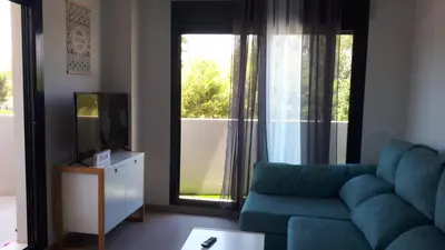 a living room with a blue couch and a television at Neo Mediterráneo in Barrio-Mar