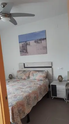 a bedroom with a bed and a picture of the beach at Neo Mediterráneo in Barrio-Mar