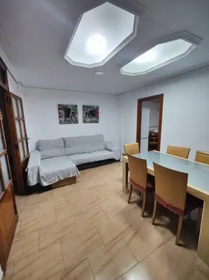 a living room with a table and a couch at Casa de pueblo grande para 7 personas in Corbera de Alcira