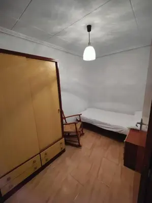 a room with a bed and a chair and a table at Casa de pueblo grande para 7 personas in Corbera de Alcira