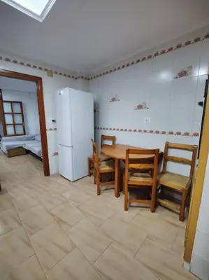 a kitchen with a table and chairs and a refrigerator at Casa de pueblo grande para 7 personas in Corbera de Alcira