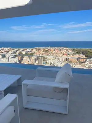 a white bench on a balcony with a view of the ocean at Apartment Gran Canet by GRENT in Canet de Berenguer