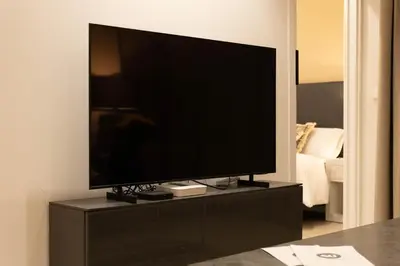 a flat screen tv sitting on a black entertainment center at Dorm4You Centro in Valencia