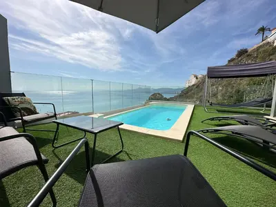 a house with a swimming pool with chairs and a table at Beautiful villa spectacular sea view in Faro de Cullera