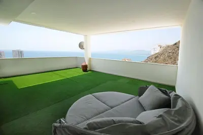 a living room with a couch and a green carpet at Beautiful villa spectacular sea view in Faro de Cullera