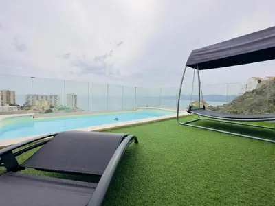 a view of a swimming pool with a swing at Beautiful villa spectacular sea view in Faro de Cullera