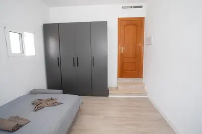 a bedroom with a bed and a wooden door at Gran Chalet con Piscina (8-10 pp) in La Eliana
